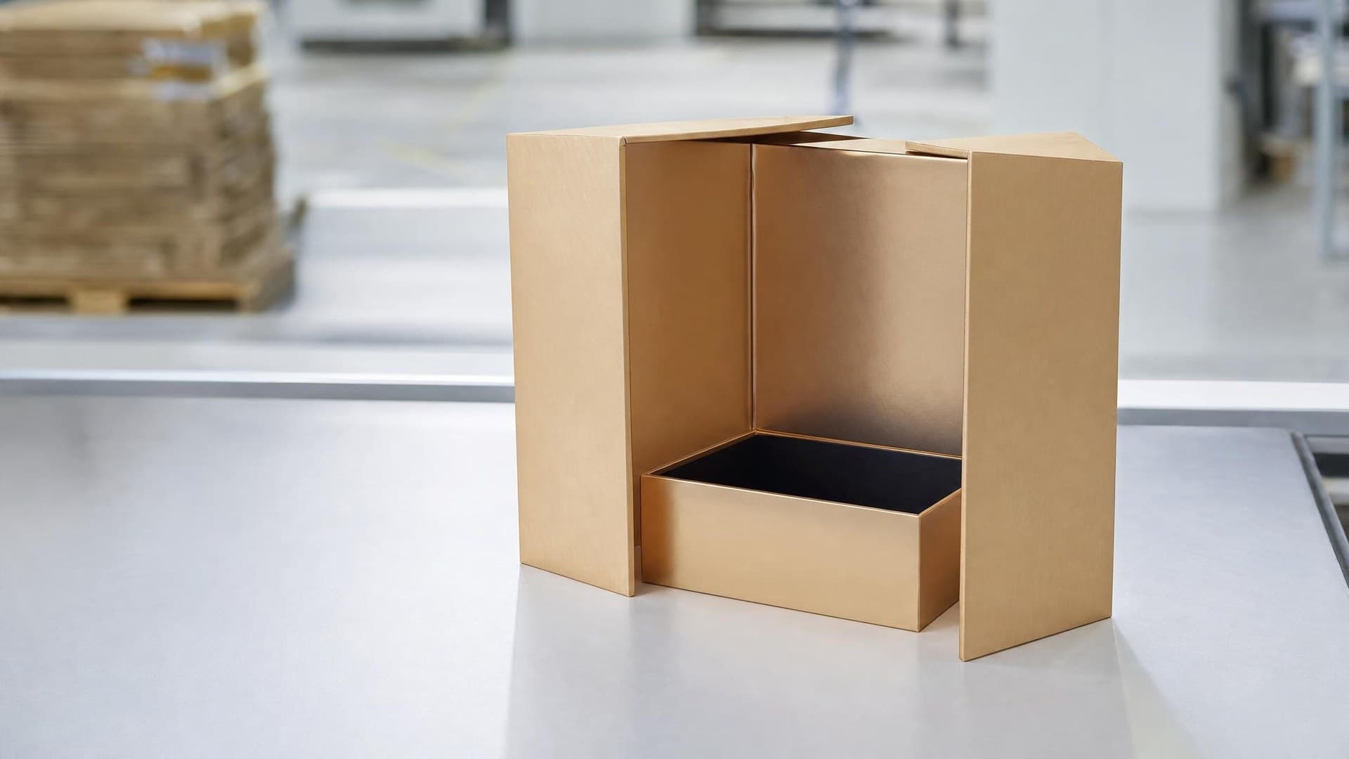 Die-cut corrugated inserts and cardboard trays stacked beside a packaging production line in a carton factory