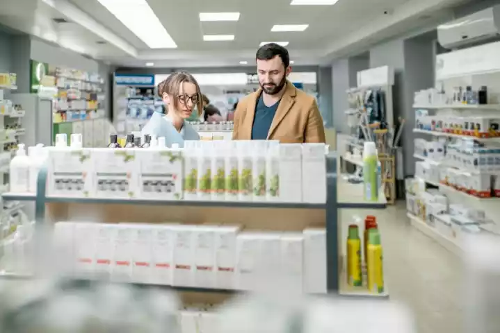 Shopper examining shelf-ready packaging in retail aisle