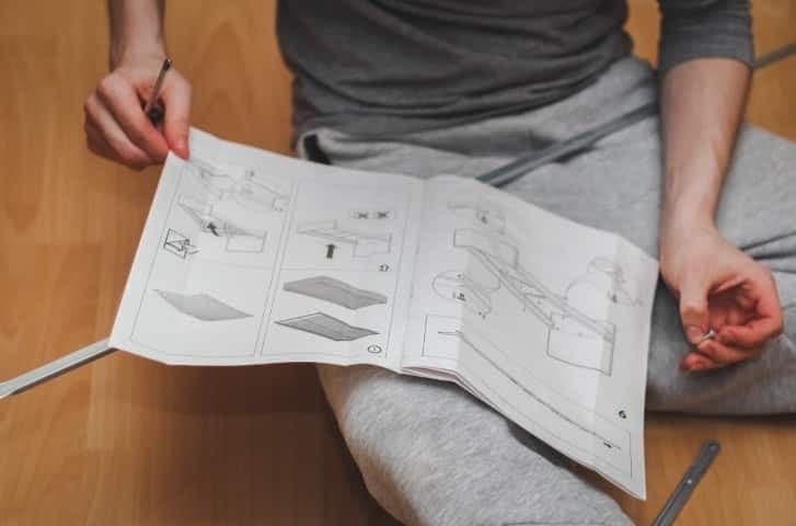 Man reading printed instruction manual