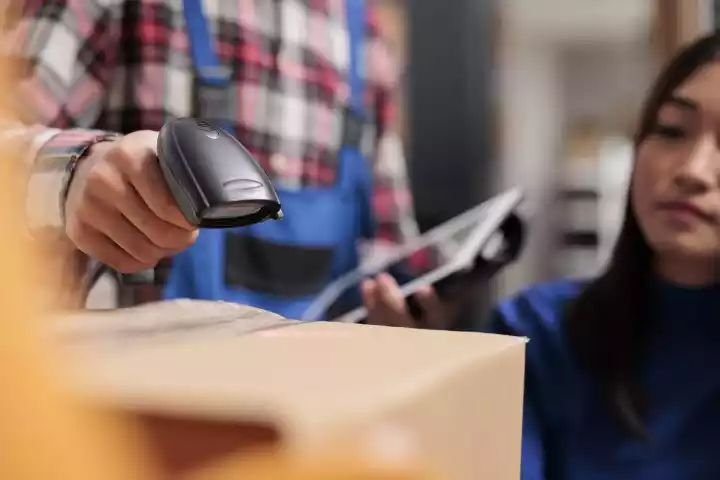 Worker scanning barcoded shipping labels