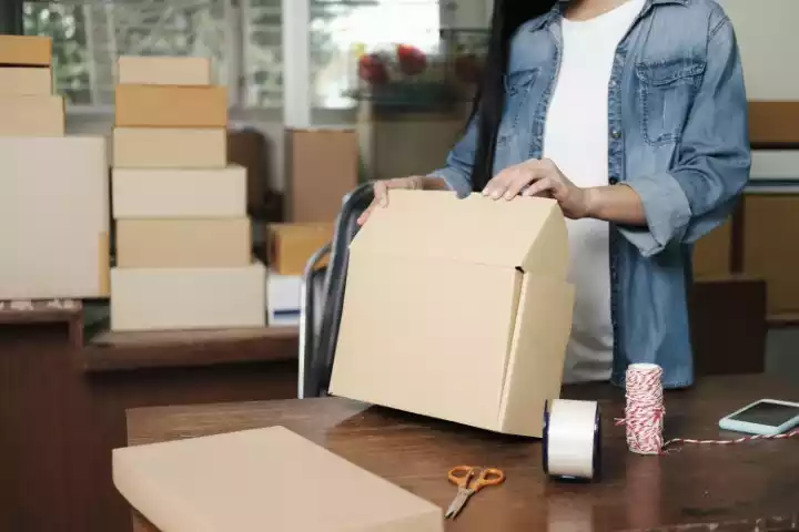 Woman holding kraft paper shopping bag and packaging boxes