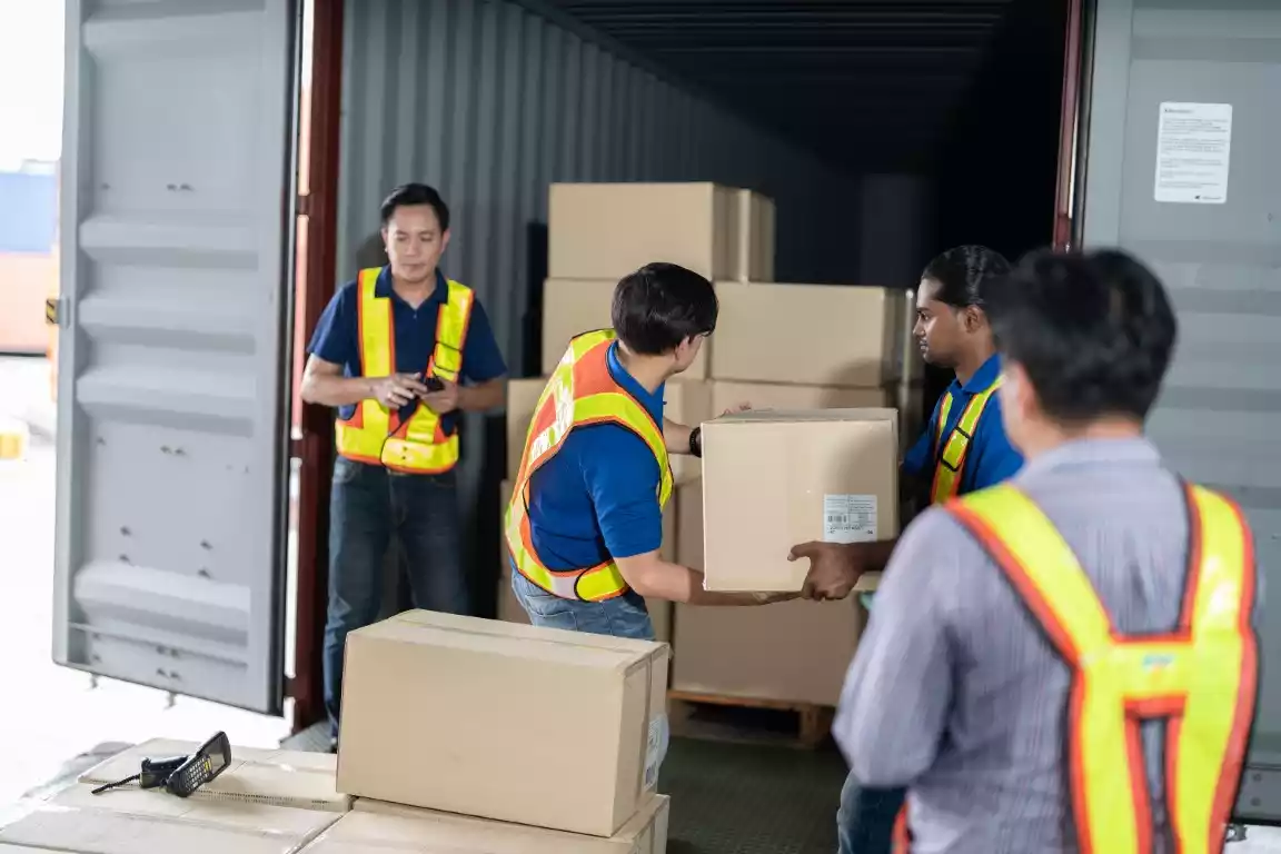 Workers loading export cartons into a 40ft container